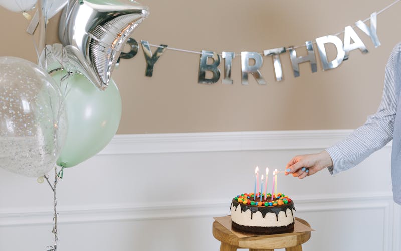 Birthday cake, balloons, and party decorations representing the occasion details