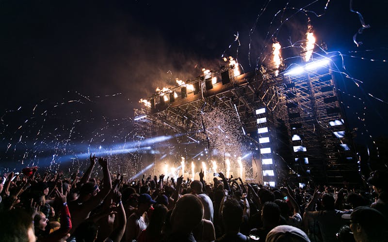 Crowd dancing together under colorful event lights